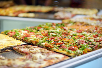 Classic New York-style pizza slices on a pizzeria counter